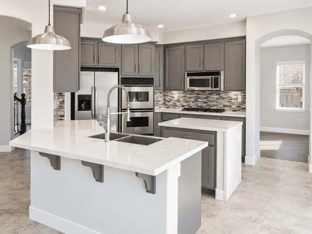 Contemporary kitchen with gray cabinets, island, and stainless steel appliances.