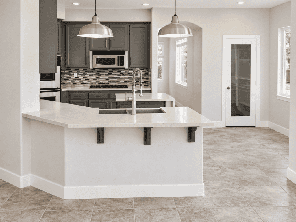 Contemporary kitchen with gray cabinets, white countertops, and stainless steel appliances.