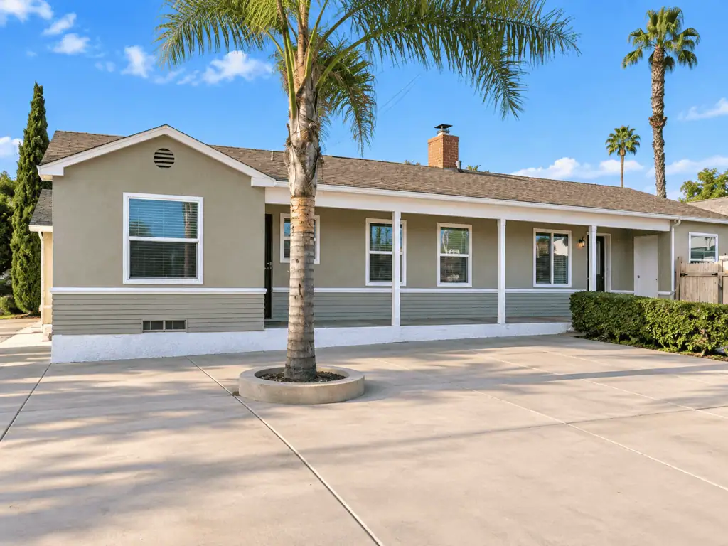Beautiful single-story house with palm trees and a clean driveway.